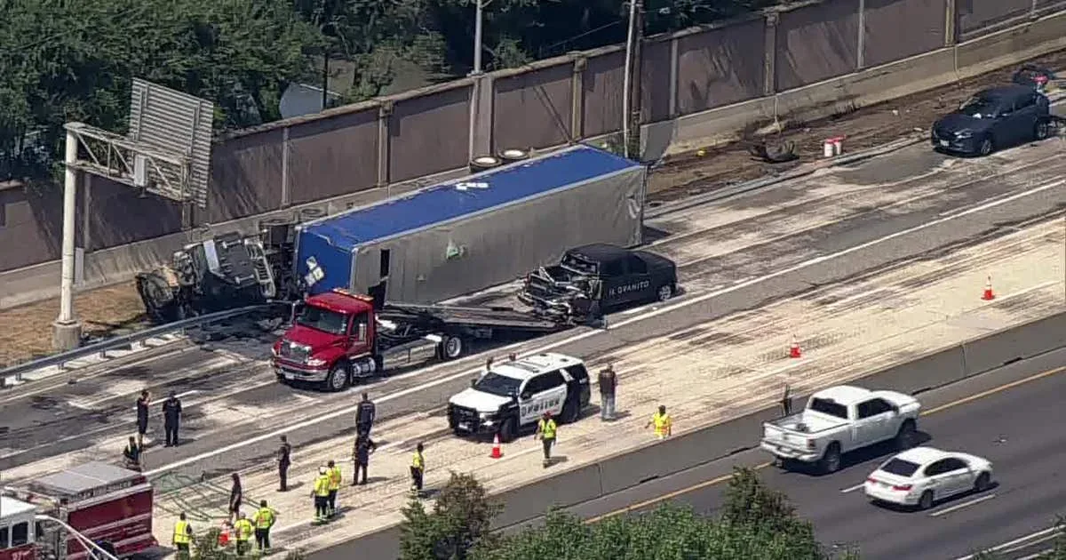 An overturned 18-wheeler and emergency response on the Dallas North Tollway after a fuel spill